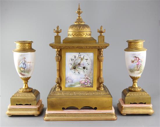 A 19th century French ormolu and porcelain clock garniture, clock height 15.5in. urns 10in. plus giltwood stands